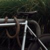 Silbernes 8bar Fahrrad mit tex-lock eyelet orange und U-Lock an Fahrradständer angeschlossen