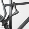 Hinterrad und Oberrohr vom Fahrrad mit schwarzem Seilschloss aus Textil an Fahrradständer angeschlossen
